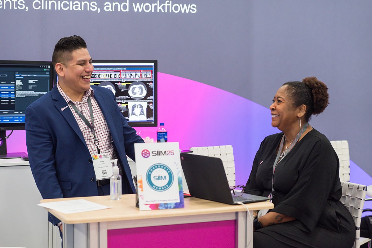 two people talking at a vendor booth during siim25