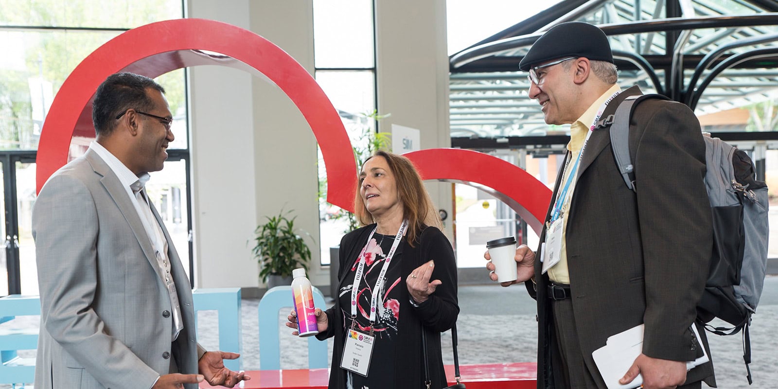 Diverse professionals networking at the SIIM Annual Meeting, discussing innovations in medical imaging and healthcare technology in a modern conference setting.