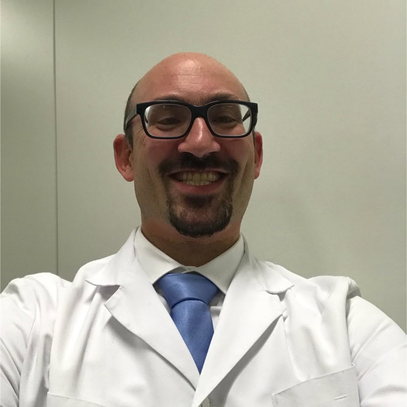 A healthcare professional in a white lab coat and blue tie, smiling at the camera at the SIIM Annual Meeting.