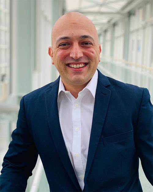 Shahab Taheri smiling at the SIIM Annual Meeting, showcasing professional attire and a confident demeanor in a modern conference setting.