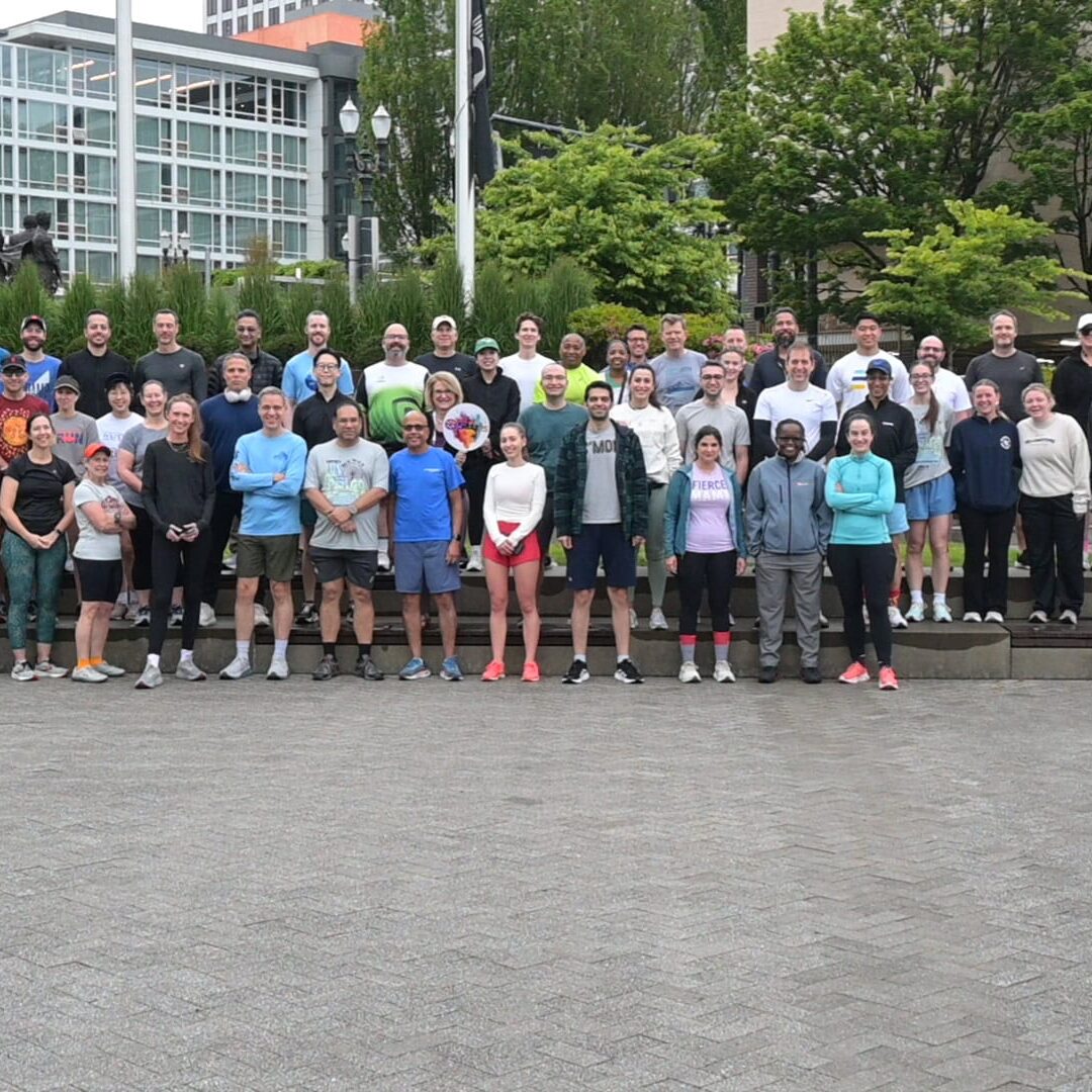 1. Large group of professionals at SIIM Annual Meeting in an outdoor urban setting with modern buildings and greenery, promoting imaging informatics and AI innovations.