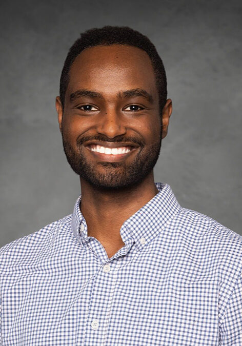 Portrait of Biniam Garomsa smiling at the SIIM Annual Meeting, showcasing professional attire and engaging presence in a conference setting.