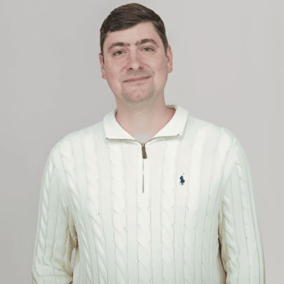 A young man smiling in a cream-colored sweater at the SIIM Annual Meeting, a leading event in medical imaging and informatics.