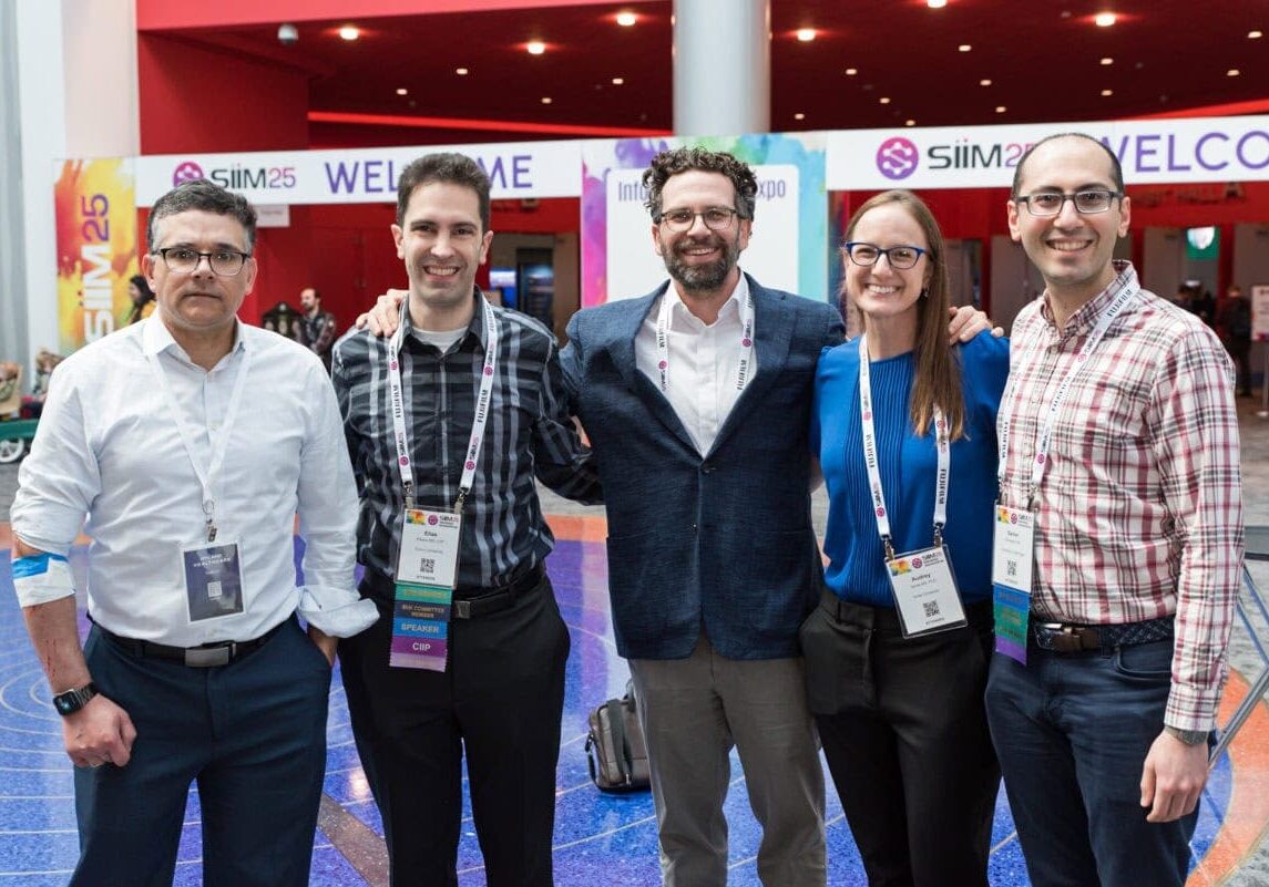 Diverse group of professionals attending SIIM Annual Meeting in a vibrant conference hall.