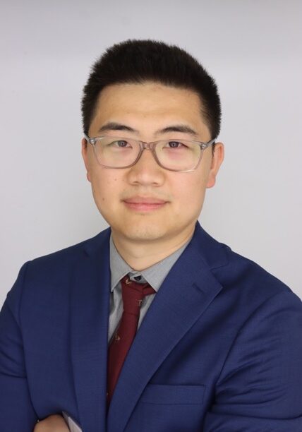 Professional portrait of Tubo Shi, MBChB, FRANZCR, attending the SIIM Annual Meeting, showcasing a medical imaging expert in formal attire.